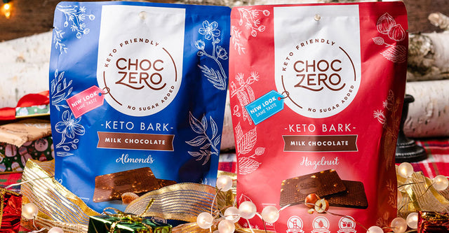 Two bags of Keto Bark surrounded by Christmas decorations