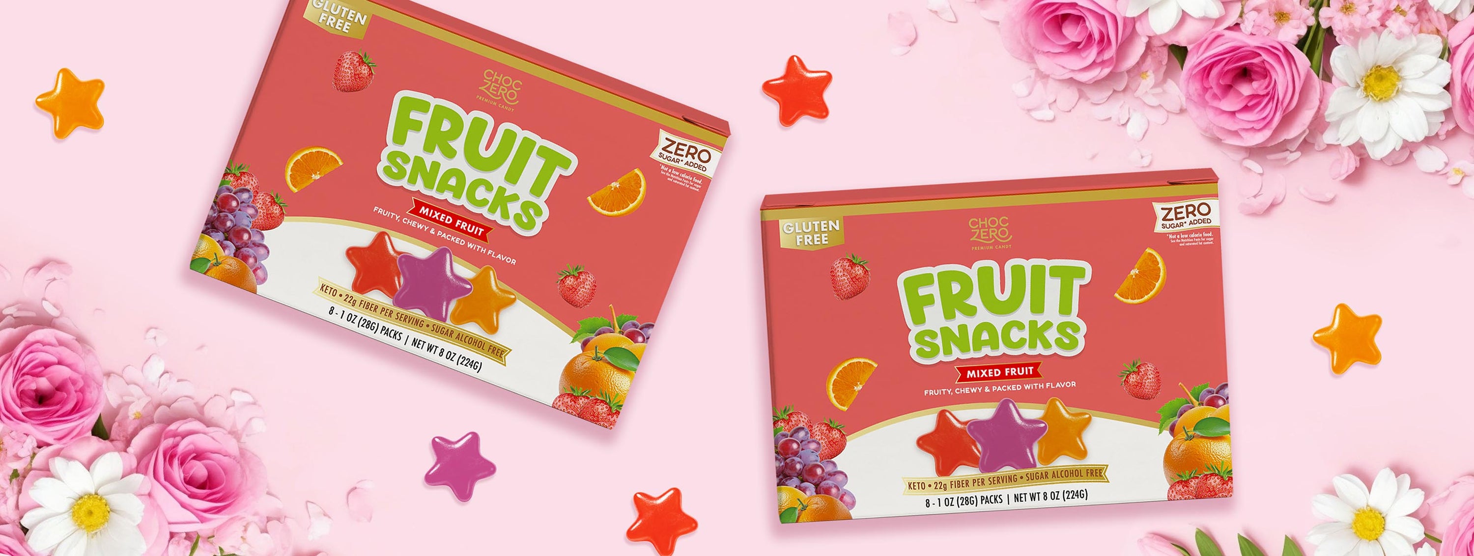 Two boxes of fruit snacks on a pink background with flowers and stars.
